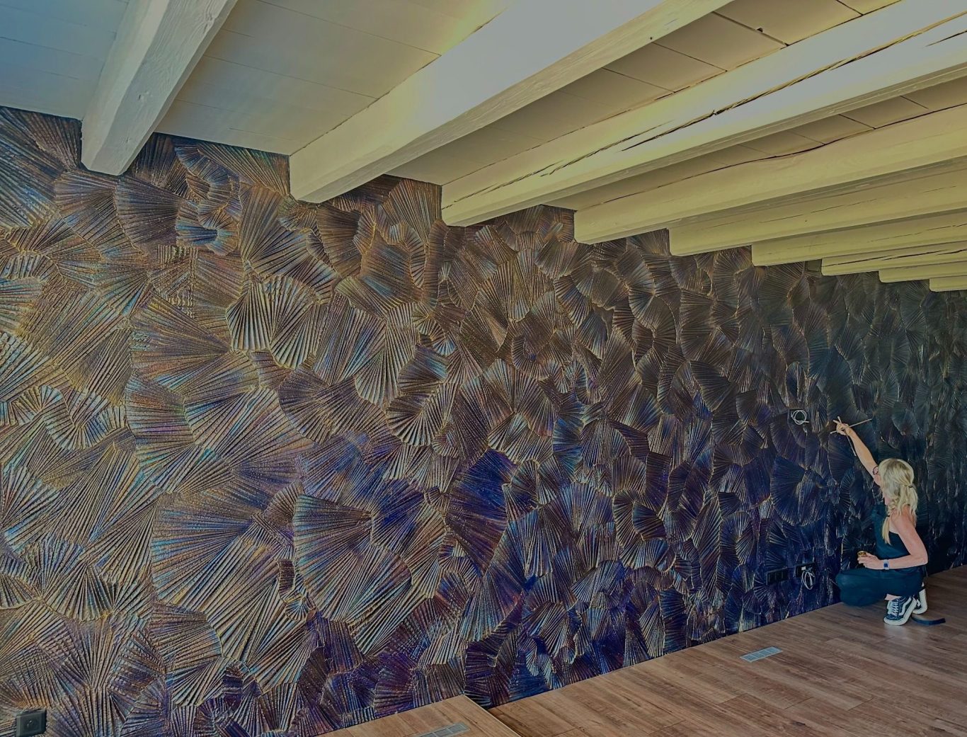 Mur artistique sculpté réalisé à la main et intégré à l’architecture d’une résidence privée, créant relief et variations de lumière.