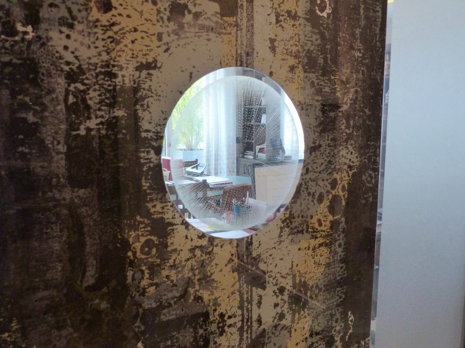 Détail d’un cercle gravé à la main sur verre dans une porte artistique – projet Club Lounge