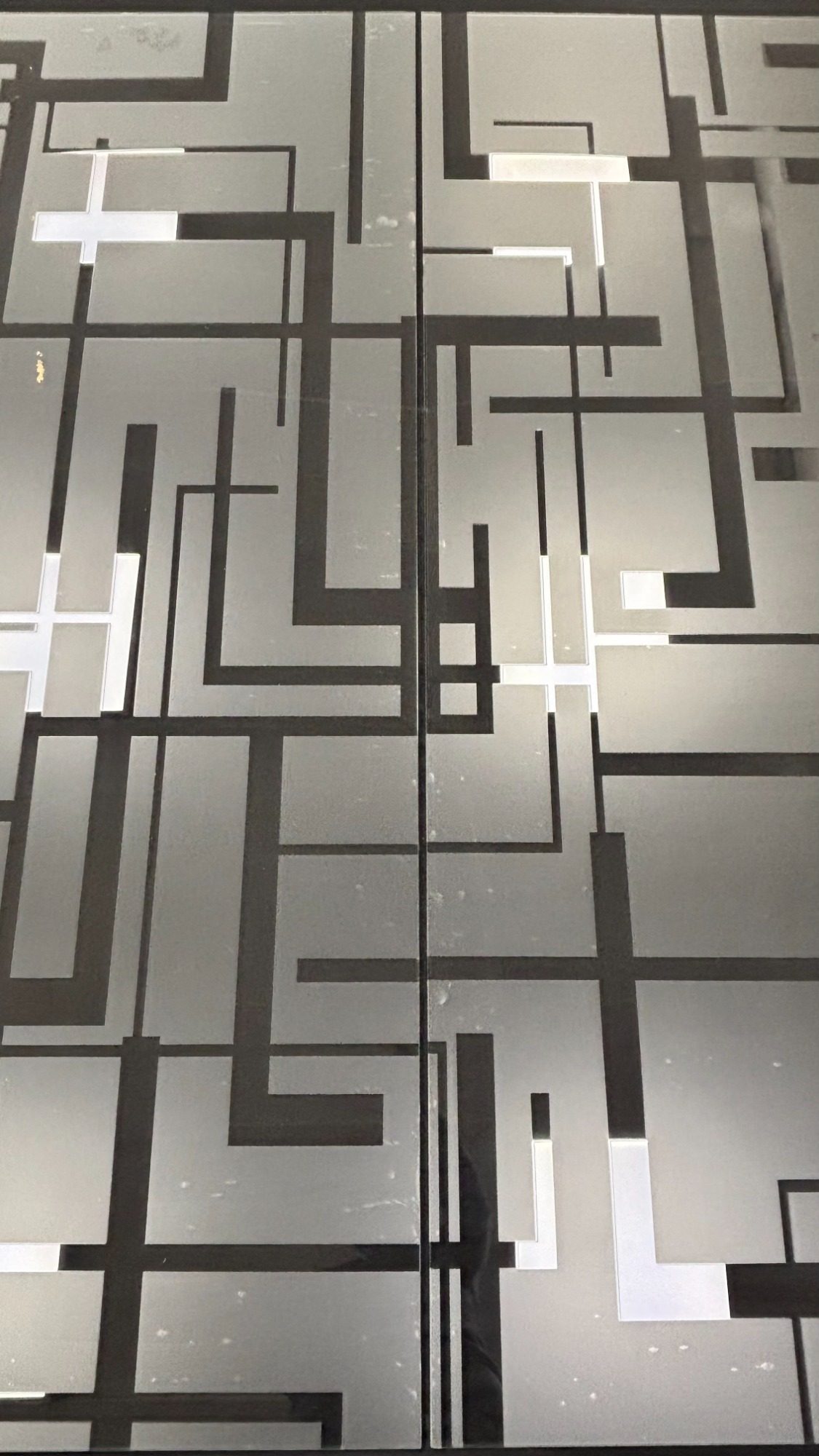 Porte artistique en verre gravé – Club Lounge Porte artistique en verre avec cercle gravé à la main intégrée dans un projet d’architecture intérieure par l’artiste Amandine Mangenot