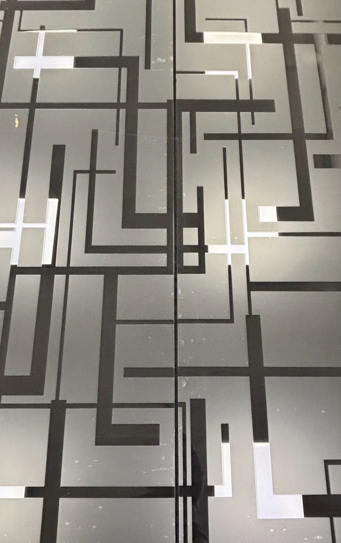 Porte artistique en verre gravé – Club Lounge Porte artistique en verre avec cercle gravé à la main intégrée dans un projet d’architecture intérieure par l’artiste Amandine Mangenot