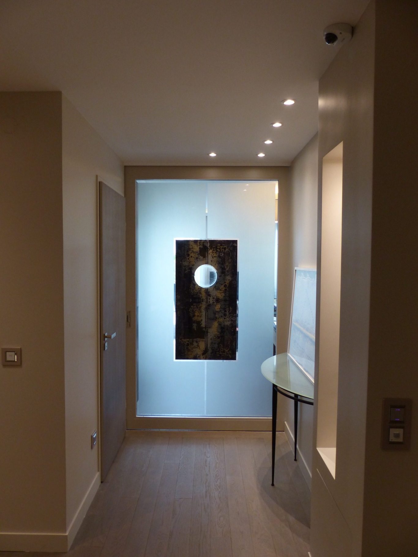 Porte artistique en verre avec cercle gravé à la main intégrée dans un projet d’architecture intérieure par l’artiste Amandine Mangenot