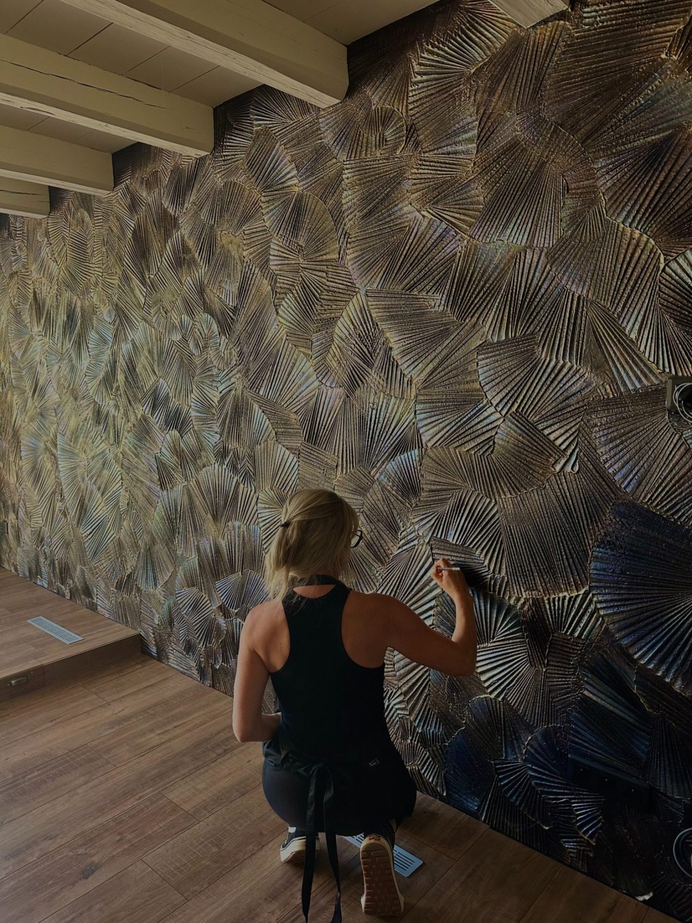 Artiste Amandine Mangenot réalisant un mur sculpté artistique en travail de matière dans une résidence privée.